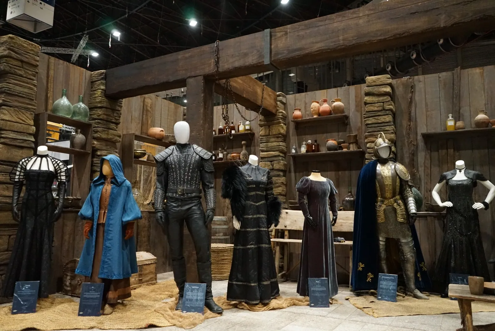 Costumes on mannequins in a wooden set built for the Netflix The Witcher exhibition